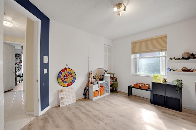 miscellaneous room with light hardwood / wood-style floors and a textured ceiling