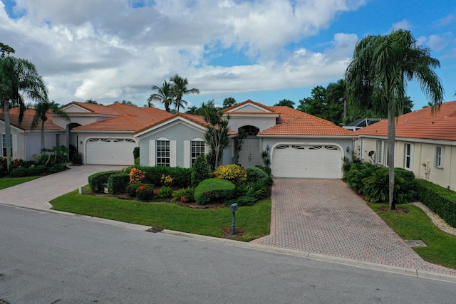 mediterranean / spanish-style house featuring a garage and a front lawn