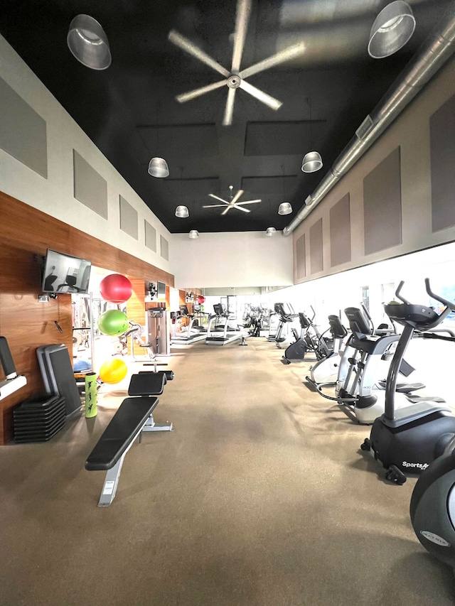 gym with wood walls and a high ceiling