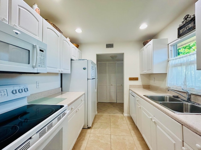 kitchen with sink, white cabinetry, white appliances, and light tile patterned floors