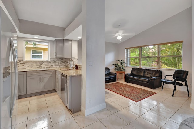 kitchen with dishwasher, sink, vaulted ceiling, gray cabinets, and light tile patterned flooring