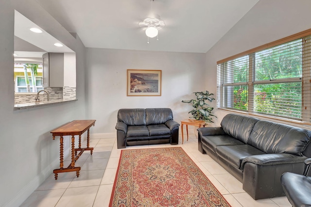 living room with ceiling fan, sink, light tile patterned floors, and vaulted ceiling