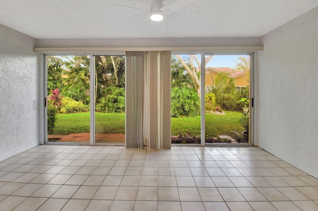 doorway with ceiling fan and light tile patterned floors