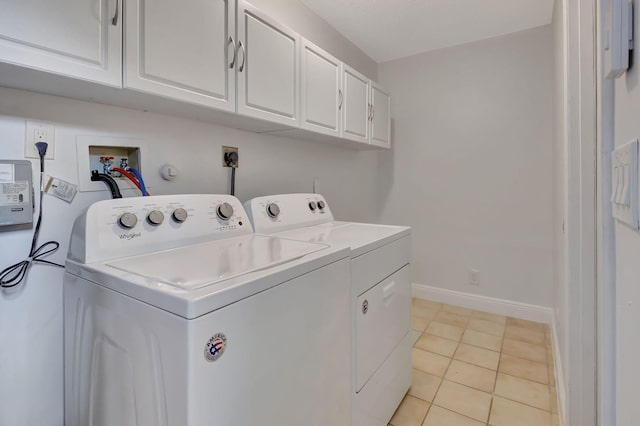 laundry area featuring washer and clothes dryer, light tile patterned floors, and cabinets