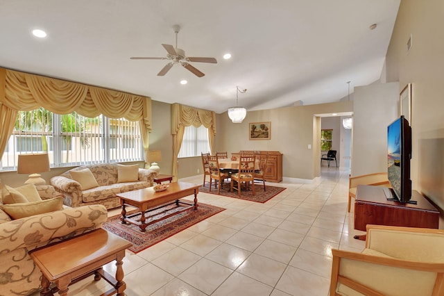 living room with ceiling fan, lofted ceiling, and light tile patterned floors