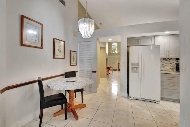 tiled dining area featuring a chandelier