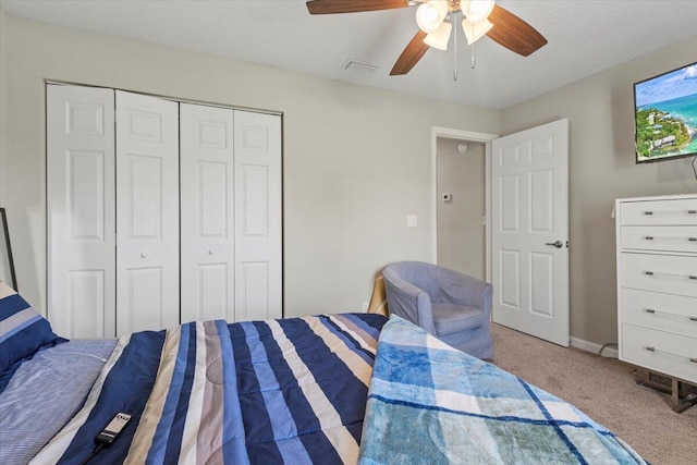 carpeted bedroom featuring a closet and ceiling fan