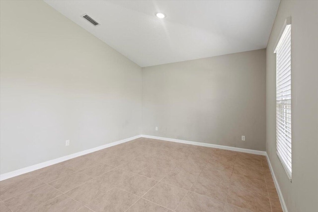 unfurnished room featuring a wealth of natural light and lofted ceiling