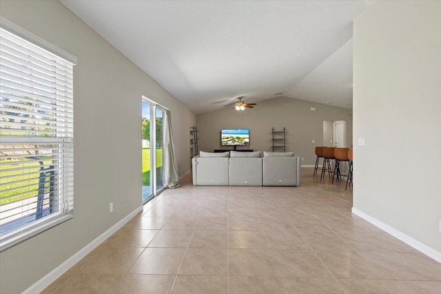 unfurnished living room featuring lofted ceiling, light tile patterned flooring, and ceiling fan