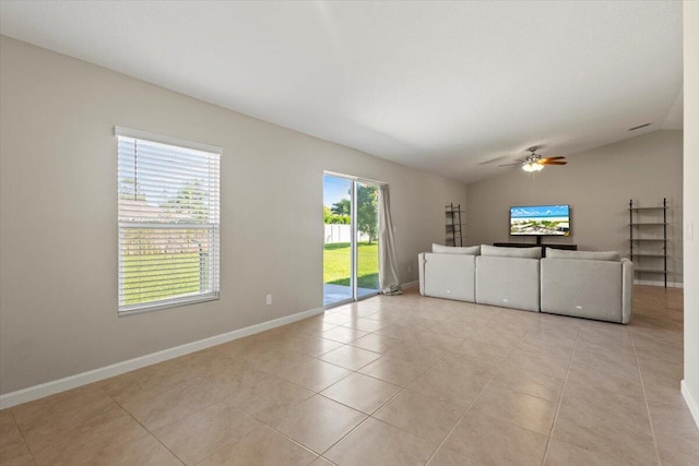 unfurnished living room featuring ceiling fan, lofted ceiling, and a wealth of natural light