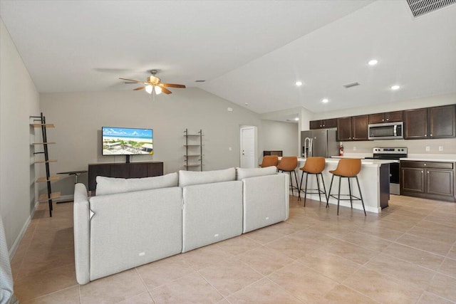 living room featuring lofted ceiling, light tile patterned floors, and ceiling fan