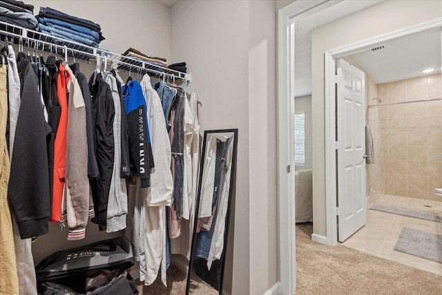 walk in closet with light tile patterned floors