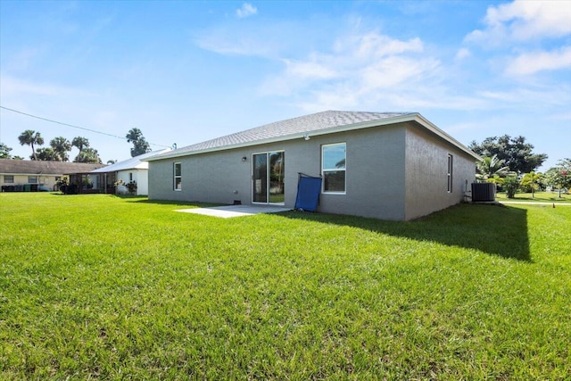 rear view of property with a patio, central air condition unit, and a lawn