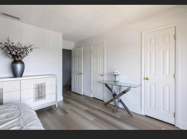 bedroom featuring wood-type flooring and a textured ceiling