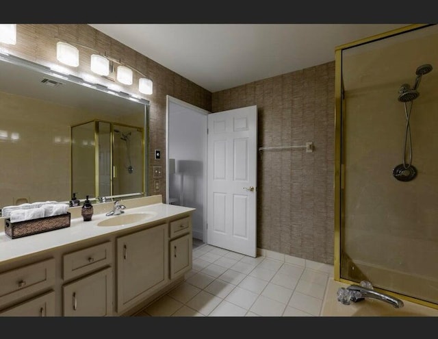 bathroom with vanity, a tile shower, and tile patterned flooring