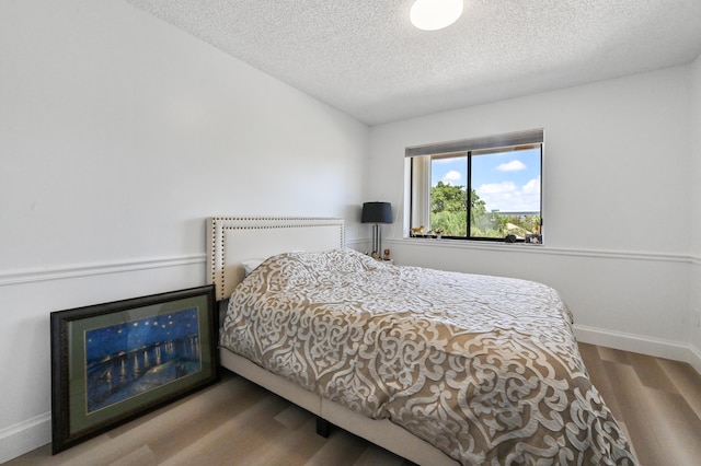 bedroom featuring a textured ceiling and hardwood / wood-style floors