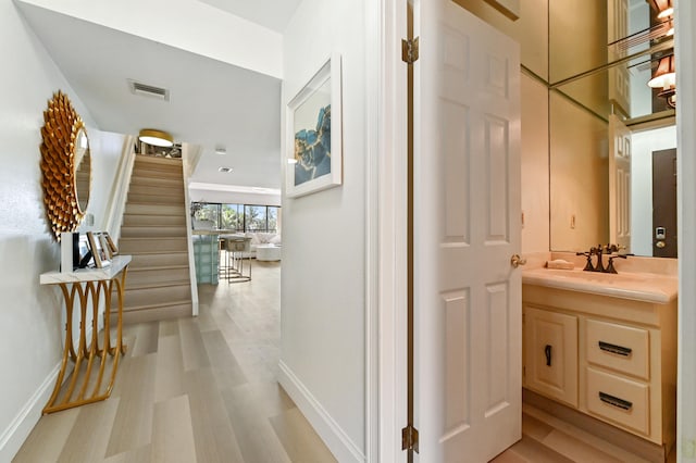 corridor featuring sink and light wood-type flooring