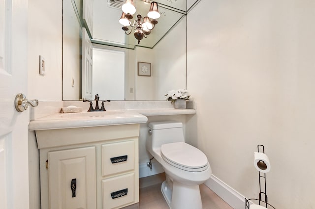 bathroom featuring vanity, toilet, and an inviting chandelier