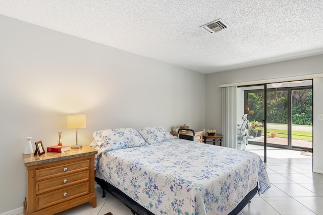 bedroom featuring a textured ceiling, access to outside, and light tile patterned floors