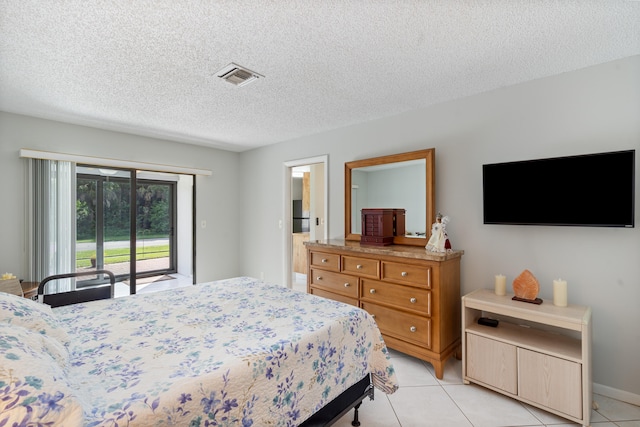 bedroom with a textured ceiling, access to exterior, and light tile patterned flooring