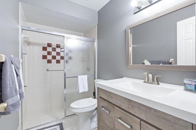 bathroom with vanity, toilet, tile patterned floors, and walk in shower