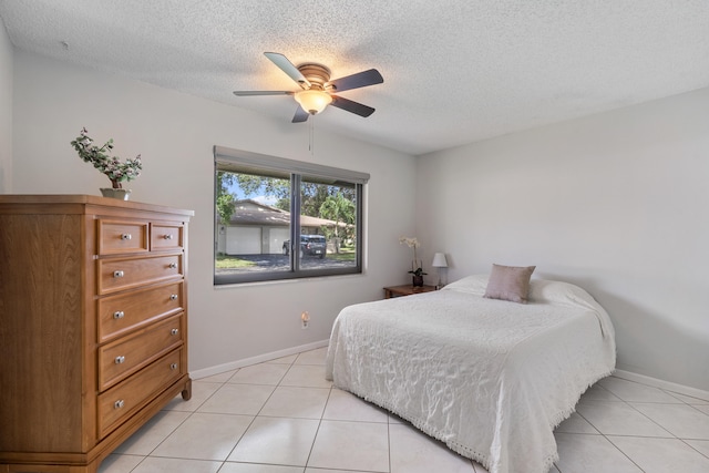 bedroom featuring ceiling fan, a textured ceiling, and light tile patterned floors