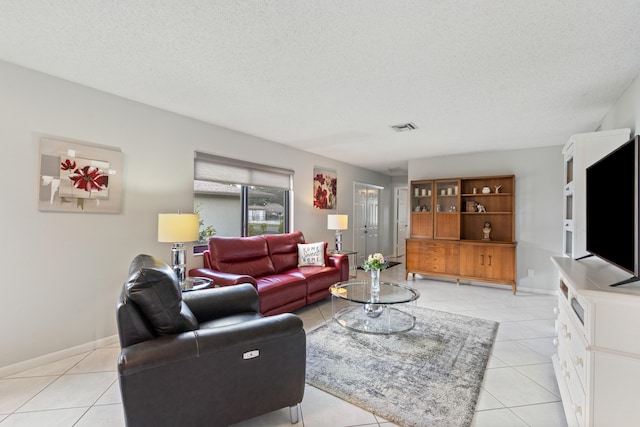 living room with a textured ceiling and light tile patterned flooring