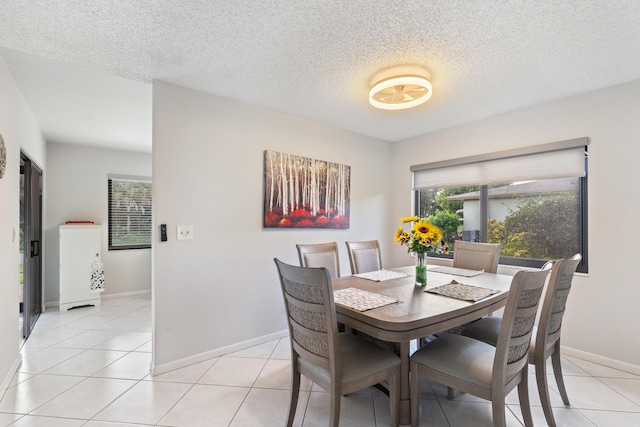 tiled dining area with a textured ceiling