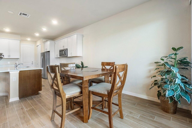 dining room with sink and light wood-type flooring