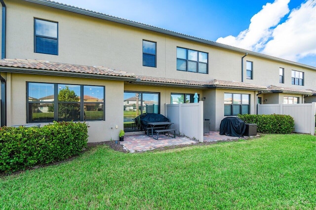 back of house with a patio area and a lawn