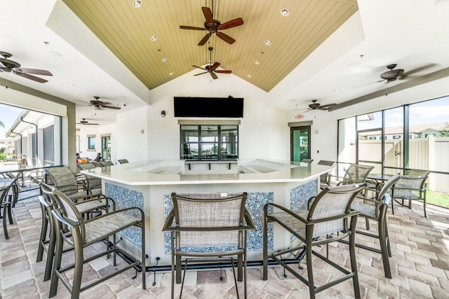 kitchen featuring high vaulted ceiling, wooden ceiling, and a wealth of natural light