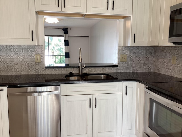 kitchen with decorative backsplash, stainless steel appliances, dark stone counters, and sink