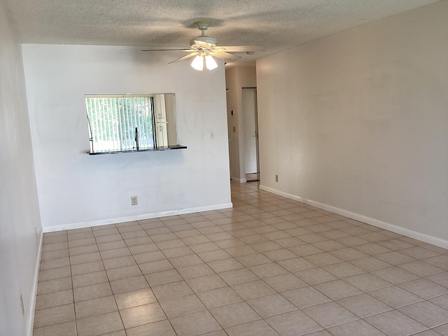 tiled spare room featuring ceiling fan and a textured ceiling