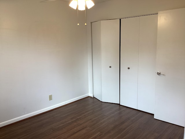 unfurnished bedroom with a closet and dark hardwood / wood-style floors