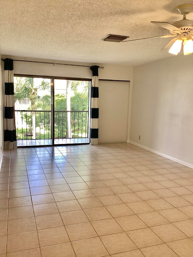 unfurnished room featuring light tile patterned flooring, ceiling fan, and a textured ceiling