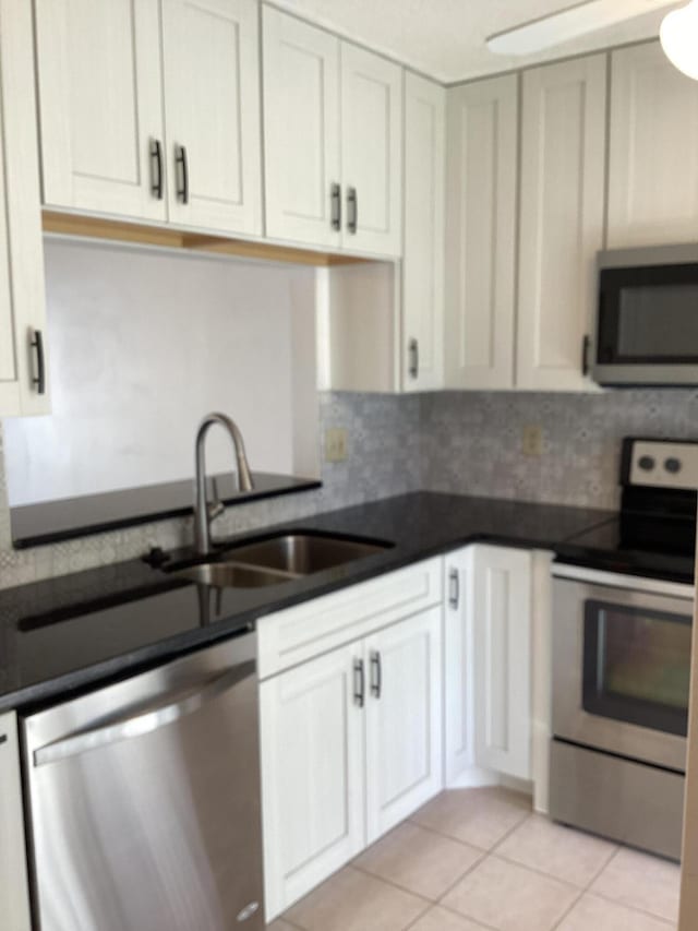 kitchen featuring decorative backsplash, white cabinetry, appliances with stainless steel finishes, and sink