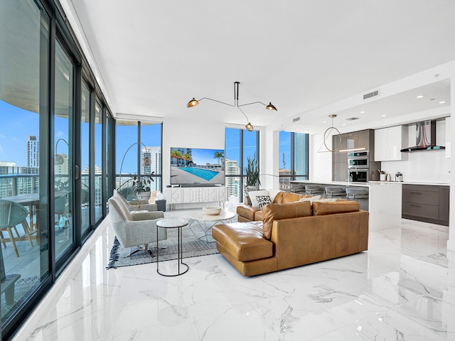 living room with an inviting chandelier and a wall of windows