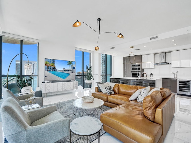 living room featuring expansive windows, sink, and beverage cooler