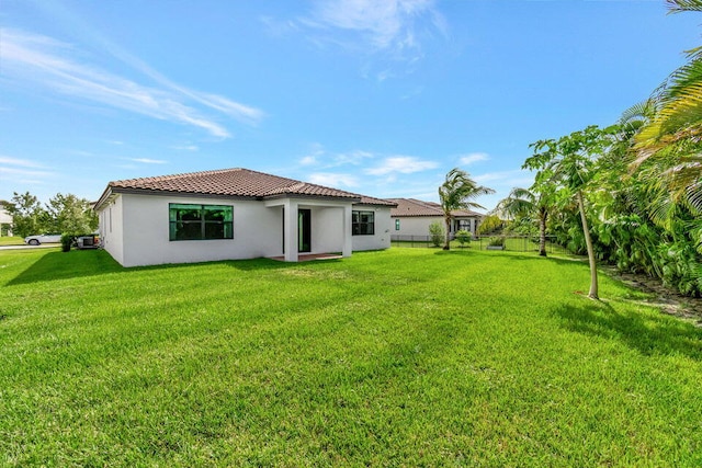 rear view of property with a lawn