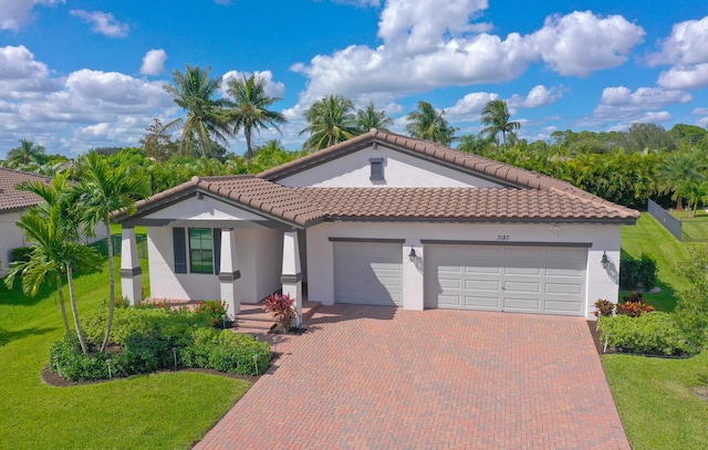 mediterranean / spanish house featuring a garage and a front lawn