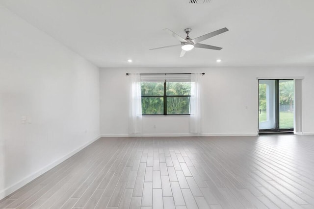 spare room with plenty of natural light, ceiling fan, and wood-type flooring