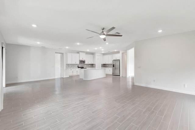 unfurnished living room with light wood-type flooring and ceiling fan