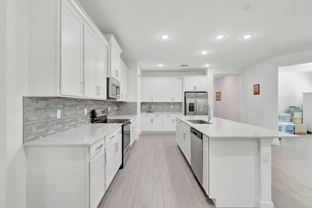 kitchen with white cabinets, light hardwood / wood-style floors, sink, and stainless steel appliances