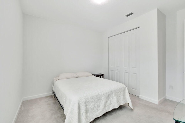 bedroom with light colored carpet and a closet