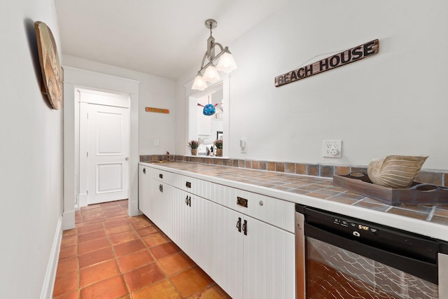 kitchen featuring tile countertops, white cabinets, sink, decorative light fixtures, and wine cooler