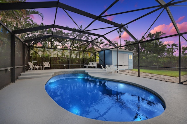 pool at dusk featuring a shed, a lanai, and a patio area