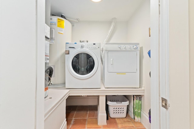 clothes washing area featuring electric water heater, separate washer and dryer, and light tile patterned floors