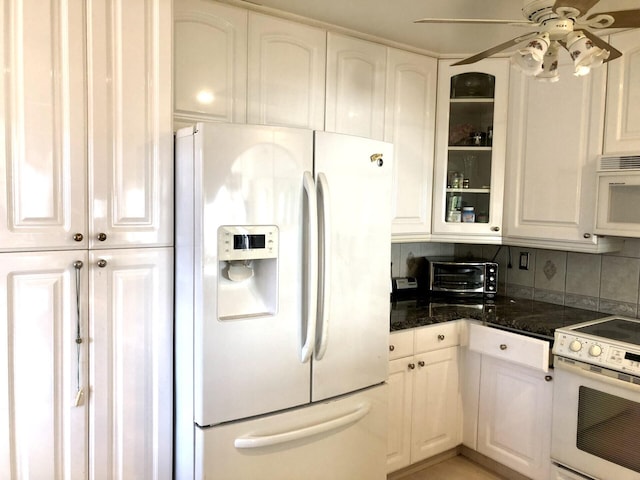 kitchen with white cabinets, tasteful backsplash, white appliances, and ceiling fan