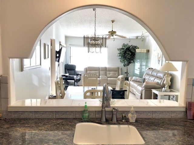 7633 S Tahiti Ln Unit 204, Lake Worth, FL 33467 - living room with arched walkways, ceiling fan, and a chandelier