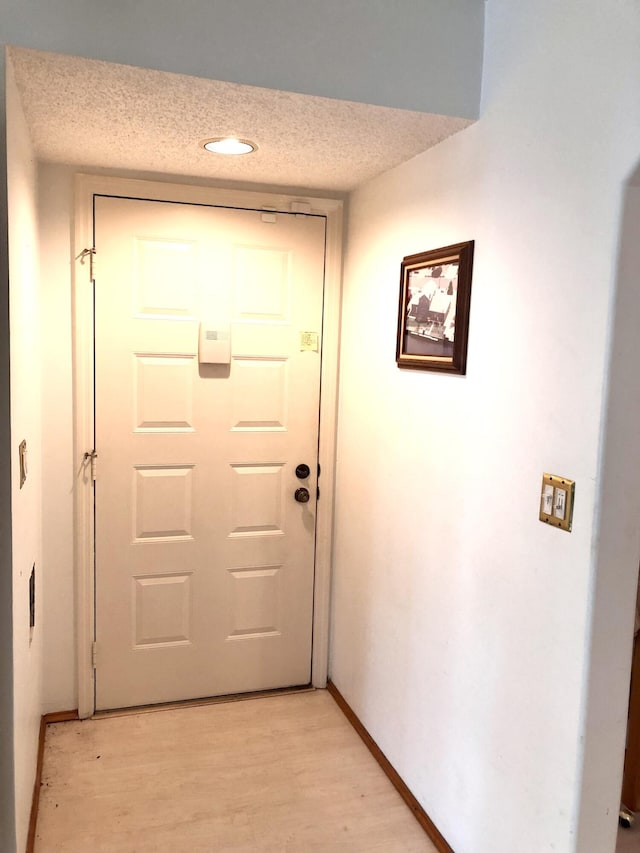 entryway featuring a textured ceiling and light hardwood / wood-style flooring